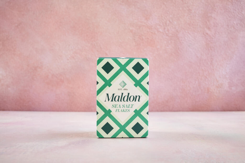 Maldon Original Sea Salt 250g pack. Pink background.