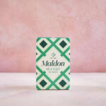 Maldon Original Sea Salt 250g pack. Pink background.