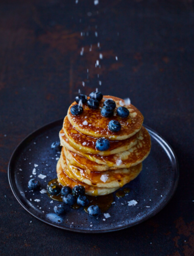 Stack of pancakes with blueberries and seasoned with sea salt