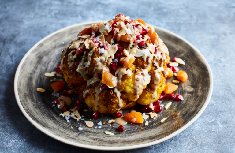 Whole roasted cauliflower with chili flakes on plate