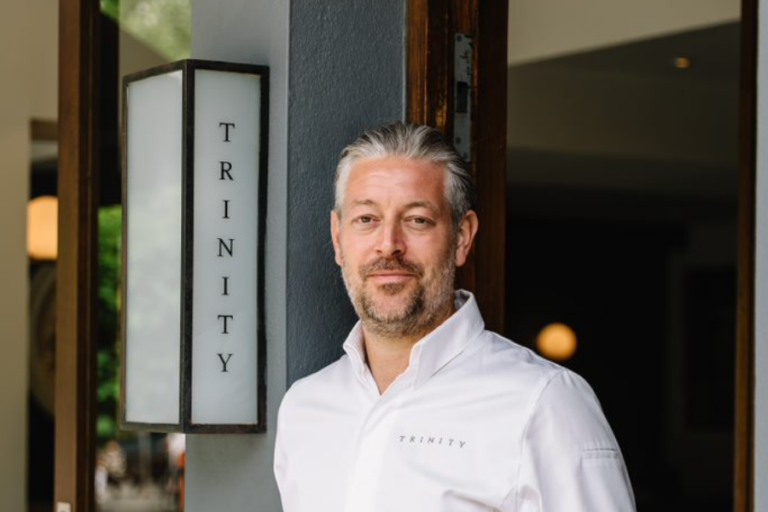 Adam Byatt next to sign for his Trinity restaurant