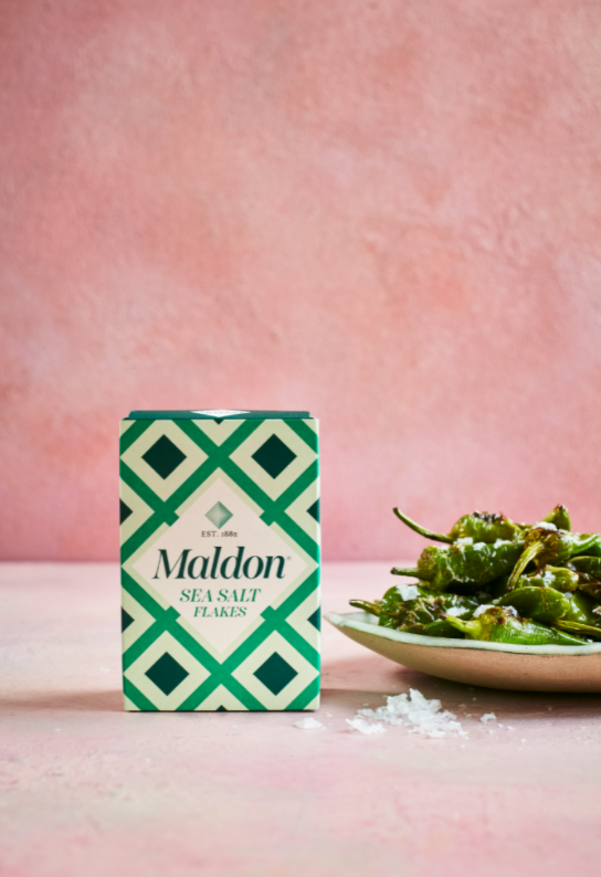 Maldon Salt flakes box next to plate of padron peppers