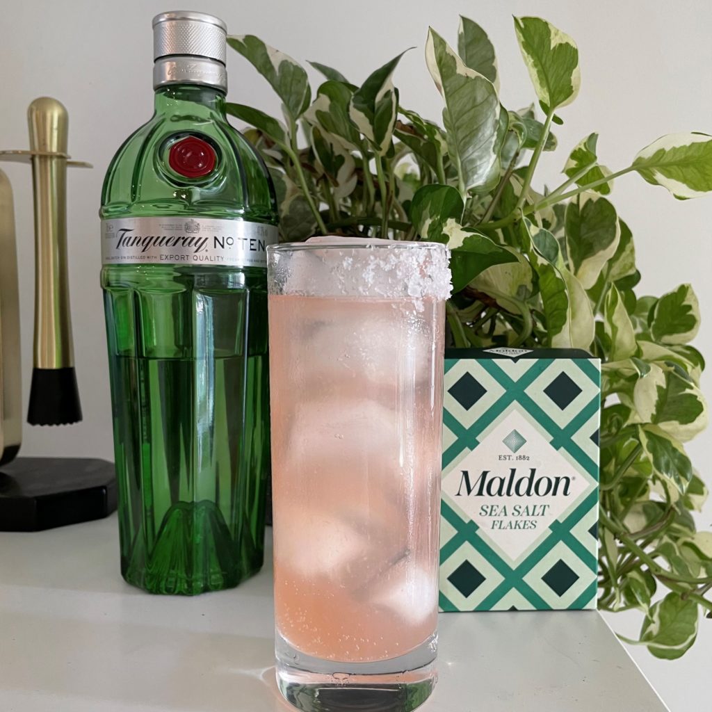 A cocktail in front of a box of Maldon Salt and Tanqueray Gin.