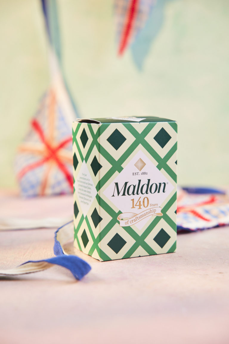 A box of Maldon Salt sits among bunting displaying the Union Jack flag.