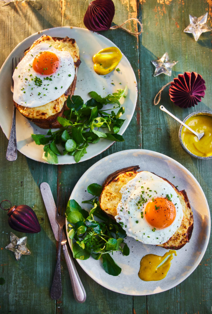 Two plates of croque madame sandwiches topped with a fried egg.