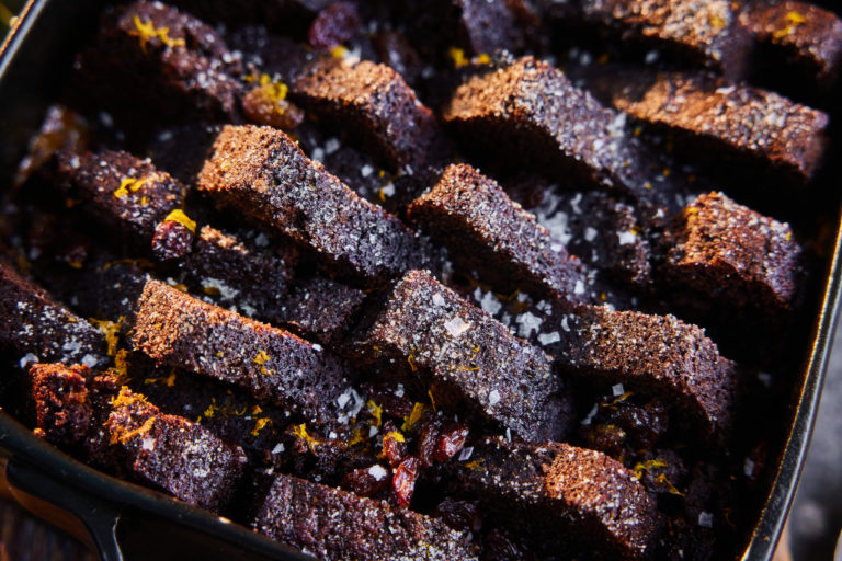 Gingerbread and butter pudding slices are arranged in a deep dish, topped with Maldon Salt.