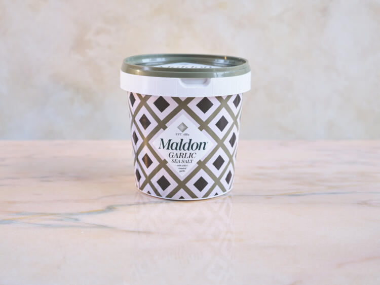 Maldon Garlic Sea Salt 500g tub. Marble background.