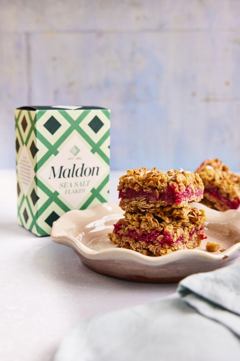 A stack of two raspberry filled flapjacks, seasoned with Maldon Sea Salt flakes