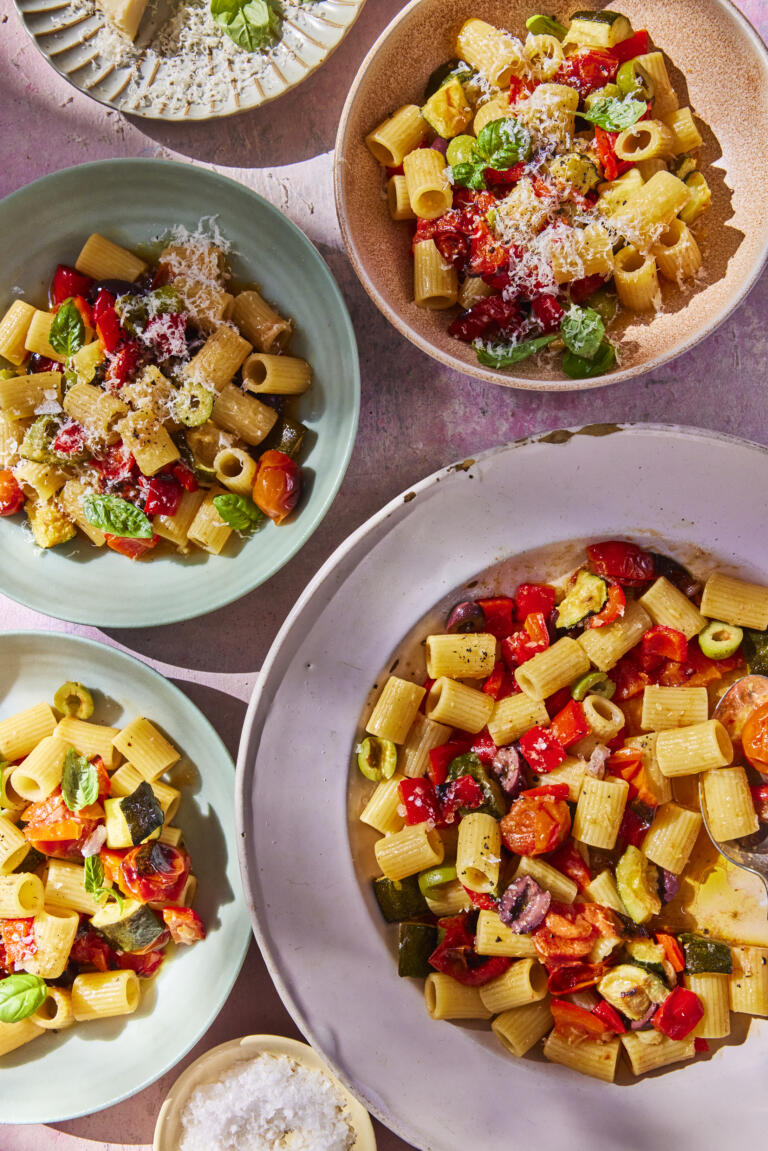Various-sized bowls filled with homemade rigatoni pasta, mixed with roasted summer vegetables. Seasoned with Himalayan Pink Salt.
